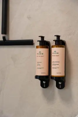 two bottles of moisturizers are on a wall at Woodz Lodges in Heusden - Zolder