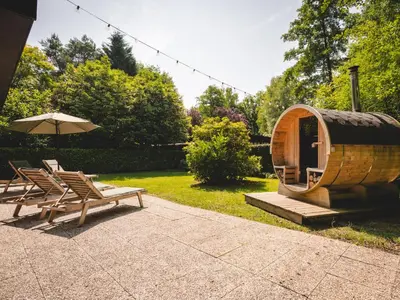 a group of chairs and an umbrella next to a sauna at Boshuisje Rekem - Alma with private sauna in Lanaken