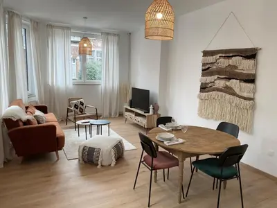 a living room with a person laying on a couch and a table at Cosy Alba plein centre Visé in Visé