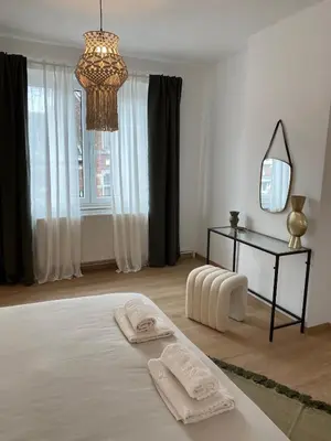 a white room with a bed with two towels on it at Cosy Alba plein centre Visé in Visé