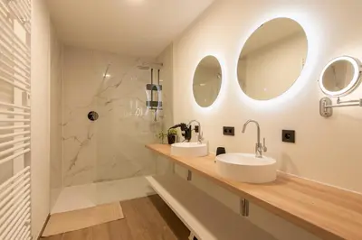 a bathroom with two sinks and a shower at NIEUW - De Grenspaal OOST 7P - 3SLPK - SAUNA - LAADPAAL in Riemst