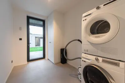 a laundry room with a washer and dryer at NIEUW De Grenspaal ZUID 2slpk - 4P - SAUNA - LAADPAAL in Riemst