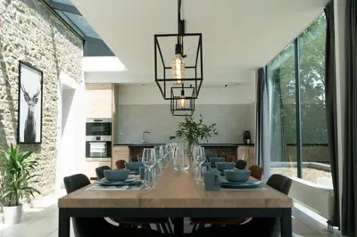 a dining room with a long table and a chandelier at Vakantiewoningen Hoeve Carpe Diem - Dalhem - Aubel - Voeren in Dalhem