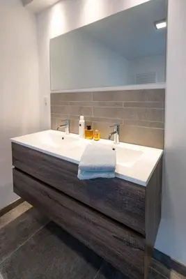 a bathroom with a white sink and a mirror at Vakantiewoningen Hoeve Carpe Diem - Dalhem - Aubel - Voeren in Dalhem