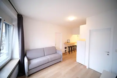 a living room with a couch and a window at Smart Appart - City Center Liege in Liège