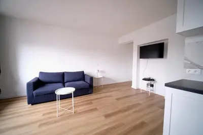 a living room with a blue couch and a table at Smart Appart - City Center Liege in Liège