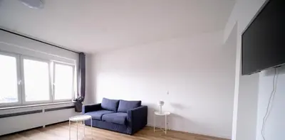 a living room with a blue couch and a tv at Smart Appart - City Center Liege in Liège