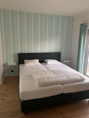 a bed with white sheets and pillows in a bedroom at 't Veldje in Tongeren