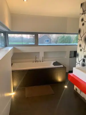 a bathroom with a large sink and a window at 't Veldje in Tongeren