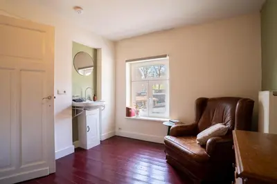 a living room with a couch and a window at Maas Suites - The French House in Lanaken
