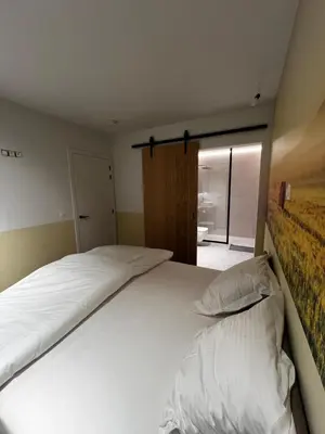 a large white bed in a room with a window at Vakantievilla Eetseveld in Bree