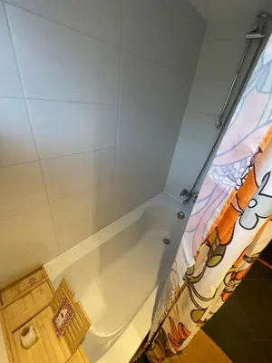 a white bath tub in a bathroom with a shower curtain at Bungalow AMNIS by Sonnevijver Residences in Lanaken
