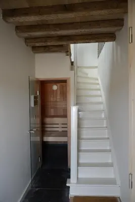 a stairway leading to a hallway with white stairs at Holiday Home Janssen & Janssen in Maasmechelen