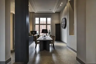 a hallway with a table and chairs and a window at Terhills Hotel in Maasmechelen