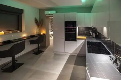 a kitchen with white cabinets and black appliances at SuiteDreams - Bali Suite Liège in Liège