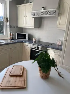 a kitchen with a wooden cutting board on a table at Happiness at Lili in Verviers