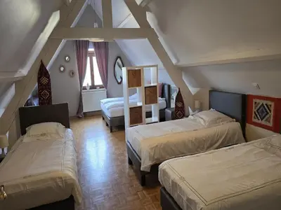 a attic bedroom with two beds and a room with two beds at Charming Group Stay in Borgloon in Borgloon