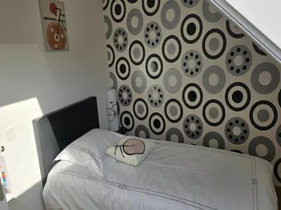 a bedroom with a white bed with a black headboard at Charming Group Stay in Borgloon in Borgloon