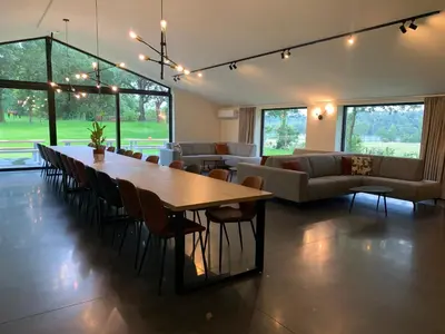 a living room with a large wooden table and chairs at Vakantiewoning Domein Goudveil in Zutendaal