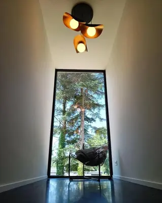 a room with a ceiling fan and a chair in front of a window at Vakantiewoning Domein Goudveil in Zutendaal