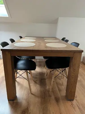 a wooden table with chairs around it in a room at Maison Isa in Lommel