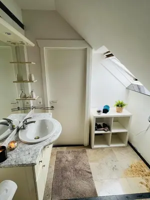 a white bathroom with a sink and a window at Maison Isa in Lommel