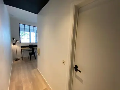 an open door to a room with a desk at 