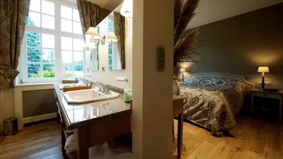 a bathroom with a sink and a bed at Lafarques in Pepinster