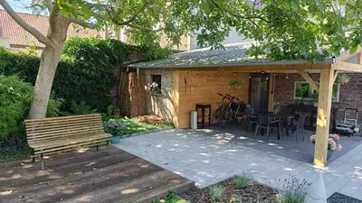 a patio with a wooden bench and a table at Gusta in Maasmechelen