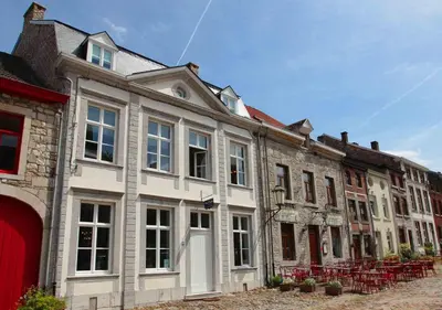 a large white building with red chairs in front of it at Le Dragon Limbourg - Luxurious & Cozy Holiday Home in Limbourg