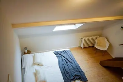 a bedroom with a white bed with a window at LOFT 44 - thuis in Hasselt in Hasselt