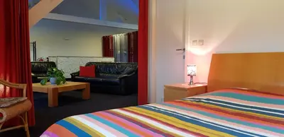 a bedroom with a bed and a chair and a couch at Apartment Campinor in Pelt