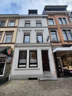 a white building with windows on a street at Louisappart - Eupen Zentrum in Eupen
