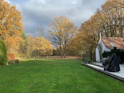 a yard with a house and trees in the background at Bokrijklodge in Hasselt