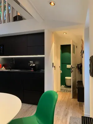 a kitchen with black cabinets and a green door at Bokrijklodge in Hasselt