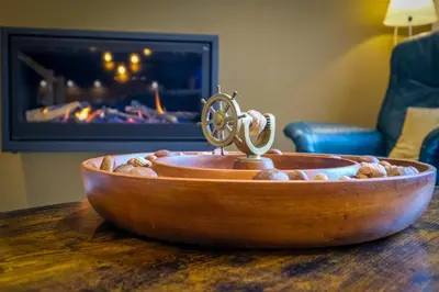 a wooden bowl on top of a table with a fireplace at Gîte La Vieille Ferme Chaudfontaine et son jacuzzi in Chaudfontaine