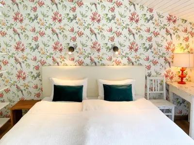 a bedroom with two beds and a floral wallpaper at Vakantiehuis Eksel in Hechtel-Eksel