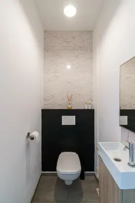 a bathroom with a white toilet and a sink at Nr 28 TravelHome in Heusden - Zolder