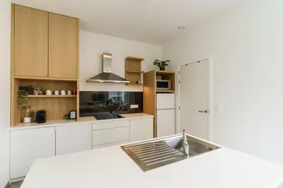 a kitchen with white cabinets and a sink at Nr 28 TravelHome in Heusden - Zolder