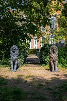 two stone lion statues in front of a house at Château de Looz in Borgloon