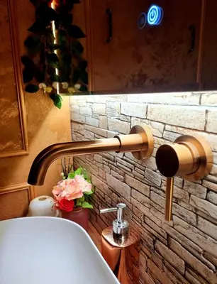 a bathroom with a bath tub and a stone wall at Aslyra 