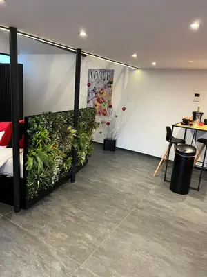 a room with a bed with plants and a table at LCforyou in Juprelle
