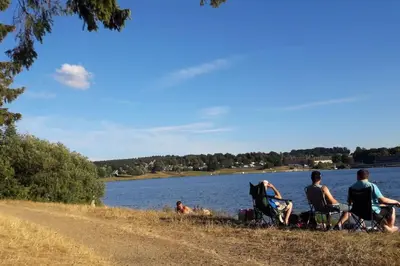 a group of people sitting on the side of a lake at WalHOME: Hohes Venn, 3 Grenzen, Natur in Walhorn