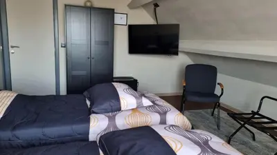 a bedroom with a bed and a tv and a chair at MARINA in Houthalen-Helchteren