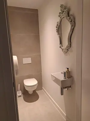 a bathroom with a toilet and a mirror at Hotel Apartments Belgium 5 - HAB 5 in Balen