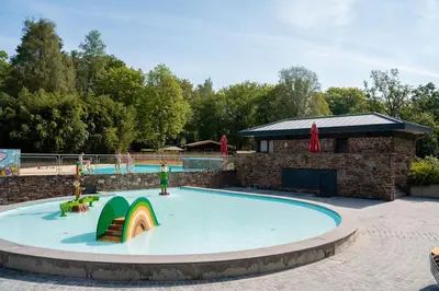 a large pool with a slide in a playground at Jocomo Parc in Lanaken