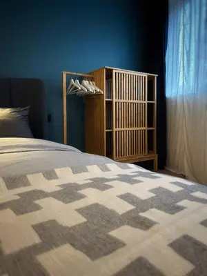 a bedroom with a bed and a wooden book shelf at Suite luxueuse aux Guillemins in Liège