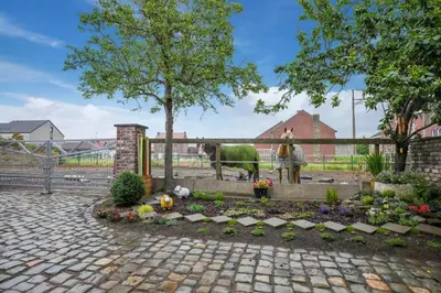 a garden with flowers and a horse in a fence at Bij Suus onder de wol in Borgloon