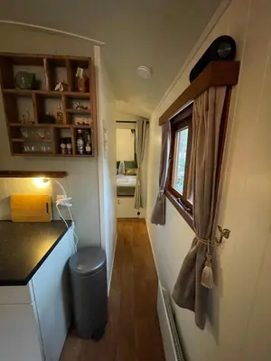 a small kitchen with a trash can in a tiny house at Pipowagen de Zwaan in Hoge Kempen nabij Maastricht in Lanaken