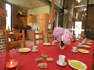 a table with a red table cloth and flowers on it at Teuven Farmhouse for 24 Guests in Teuven